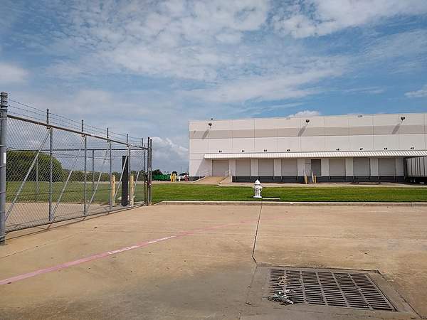 1655 Waters Ridge Dr, Exterior Building Photo - MultiQuip side as seen from 1601 Waters Ridge (Includes Anixter outside storage fence). Industrial Property for Lease - 1655 Waters Ridge Dr, Lewisville, Texas, 75057-6013 (2)
